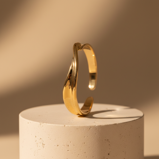 Minimal polished gold-tone open cuff bracelet on cream stone